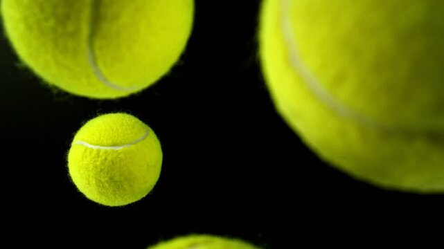 Super Slow Motion of Falling Tennis Balls. Isolated on Black Background. Top View. Filmed on High Speed Cinema Camera, 1000fps.