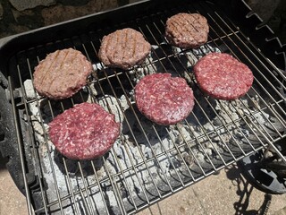 Grilled burgers on charcoal grill for summer barbecue gathering