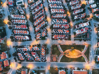 Streetlights illuminating a residential neighborhood at dusk, showcasing urban planning and modern...