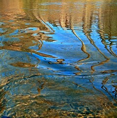 Colorful reflection in the water. Easy flow of the river. Wave. Relaxing photo. Shoreline. Postcard. A wrapper. Poster. Banner. Background