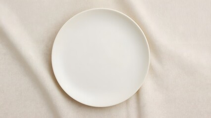 Empty white plate on beige linen fabric