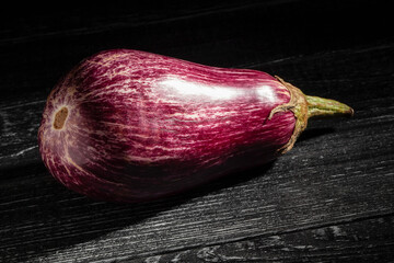 marble eggplant on black wood background