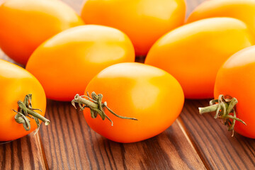 orange plum tomato on wood background