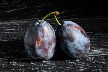 prune plum on black wood background