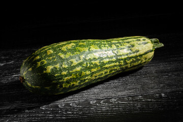 marrow zucchini on black wood background
