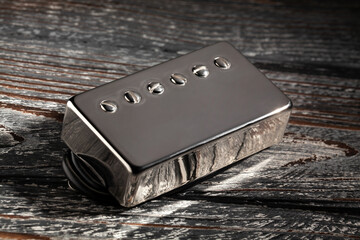 humbucker pickup on black wood background