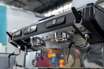 Shiny espresso machine with dual group heads, buttons and steam wands