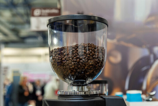 Transparent coffee grinder filled with roasted beans - Powered by Adobe