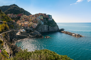 Colorful houses on the cliffs and the blue sea of Manarola, Cinque Terre, Italy.