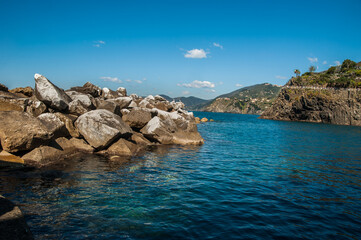 stones and turquoise waters of the Mediterranean Sea off the coast of Manarola, Cinque Terre, Italy