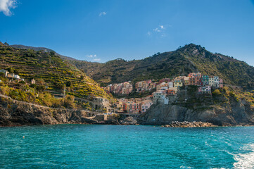 Monterosso al Mare, Cinque Terre, a seaside village with colorful buildings nestled between terraced cliffs above the blue waters of the Ligurian Sea.