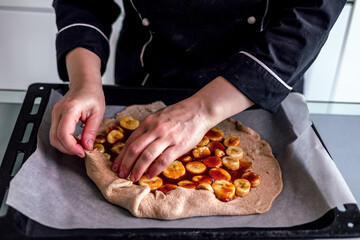 Close up view of baker is working. Homemade pie. Hands preparing dough on table. 