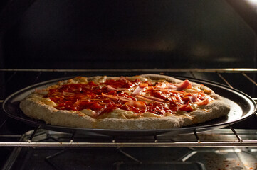 Homemade whole‑wheat pizza with mozzarella and mushrooms on a tray in the oven.