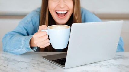 A smiling caucasian female holds a mug at her home desk with a computer in front. Concept of work-life balance. - Powered by Adobe