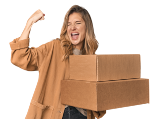 Blonde Caucasian moving with large boxes raising fist after a victory, winner concept.