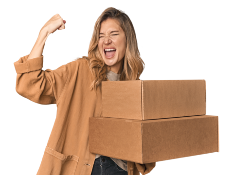 Blonde Caucasian moving with large boxes raising fist after a victory, winner concept.