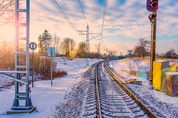  A railroad stretching into the distance against the backdrop of a winter sunset