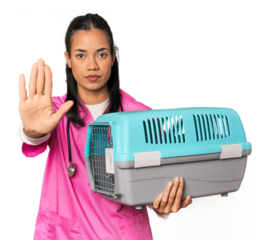 Young Filipina vet holding pet carrier standing with outstretched hand showing stop sign, preventing you.