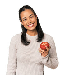 Young Filipina holding a tomato happy, smiling and cheerful.