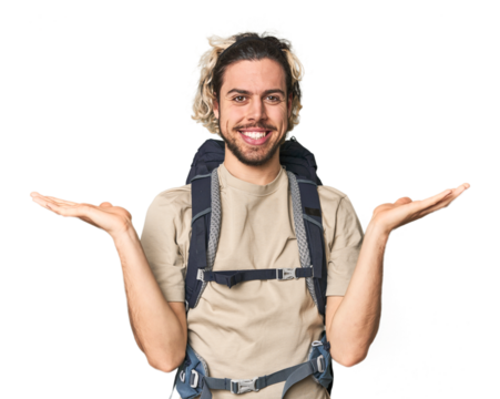 Young Caucasian hiker with backpack makes scale with arms, feels happy and confident.