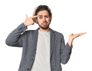 Young businessman in casual blazer holding and showing a product on hand.