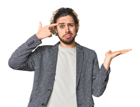 Young businessman in casual blazer holding and showing a product on hand.