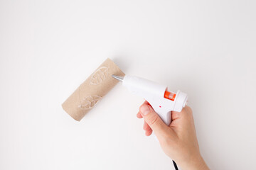 Step in crafting process with hand applying hot glue over leaf sketch on cardboard, great for...
