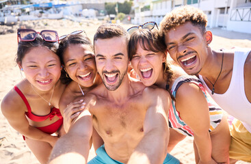 Group of cheerful gen z tourist in swimwear taking a happy selfie on the beach for journey memories. Diverse friends laughing enjoying leisure time and having fun in summer vacations