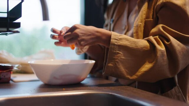 Young cook's hands preparing a surimi and vegetable salad in a kitchen