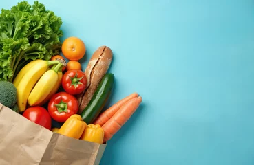 Fototapeten Grocery paper bag full fresh fruits vegetables on blue background. Variety of organic food. Healthy eating diet concept. Delivery service shopping concept. Flat lay, top view, copy space. Fresh food © miss irine