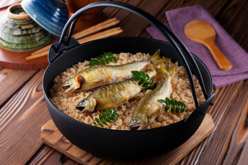 【鮎めし】塩焼きした鮎をお米といっしょに炊いた鮎めし。豊かな風味と川魚の苦味を楽しむ夏の味覚です。