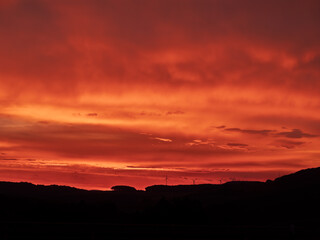 Vivid Dramatic Sunset Over Rural Landscape with Clouds