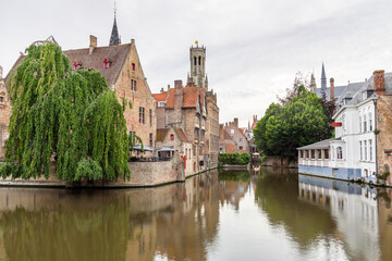 Historic brick buildings along a canal in Bruges city centre, Belgium, at dusk in summer