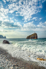 Amazing view of sea waves crashing on the shore and flowing above seashore pebbles.