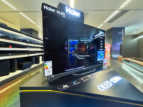 Alicante, Spain - June 11, 2025: Haier OLED television displayed in a modern electronics store, showcasing vibrant colors and advanced technology features for an immersive viewing experience