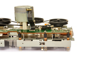 magnetic tape mechanism of an old double cassette tape recorder on a white background. Close-up ....