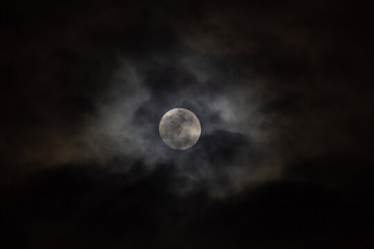 Full moon in the night sky with clouds. 