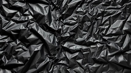 Dramatic black plastic crumpled texture background, dark abstract pattern, close-up detail. - Powered by Adobe