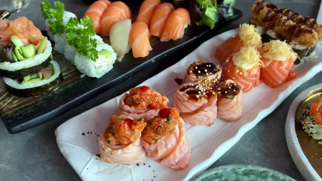 Sushi and rolls in plate. Close-up of sushi rolls on rectangle sushi plate. A set of fresh sushi rolls with salmon, avocado and black sesame seeds served on a plate with chopsticks. Japanese seafood 