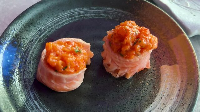 Sushi and rolls in plate. Close-up of sushi rolls on rectangle sushi plate. A set of fresh sushi rolls with salmon, avocado and black sesame seeds served on a plate with chopsticks. Japanese seafood 