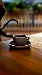 Person pouring hot water into a cup	
