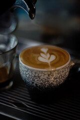 A cup of hot latte with froth art on café counter