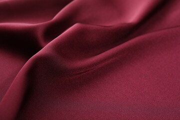 Fototapeta premium Crumpled burgundy silk fabric as background, closeup