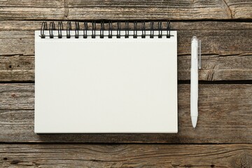 Notebook and pen on wooden table, flat lay