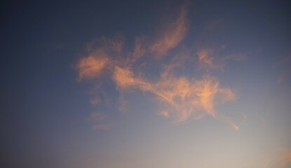 the afternoon sky is clear with yellow clouds highlighted by the sunlight