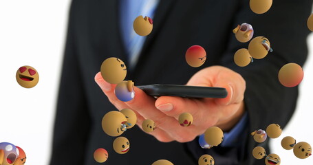 Extending hand in dark suit jacket displaying smartphone in studio, with floating emoji reactions