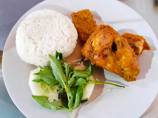 Fried country chicken served on a white plate. Indonesian culinary