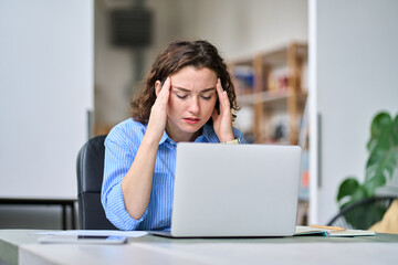 Stressed professional business woman employee office worker touching head feeling fatigue, headache migraine pain or stress. Tired dizzy young lady exhausted after computer work, having burnout.