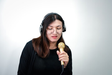 Beautiful asian woman (LGBTQ) is a singer. She enjoying sing a song or karaoke in music studio with...