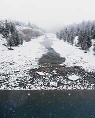 Snow covered rocks on the side of a river in New Zealand.